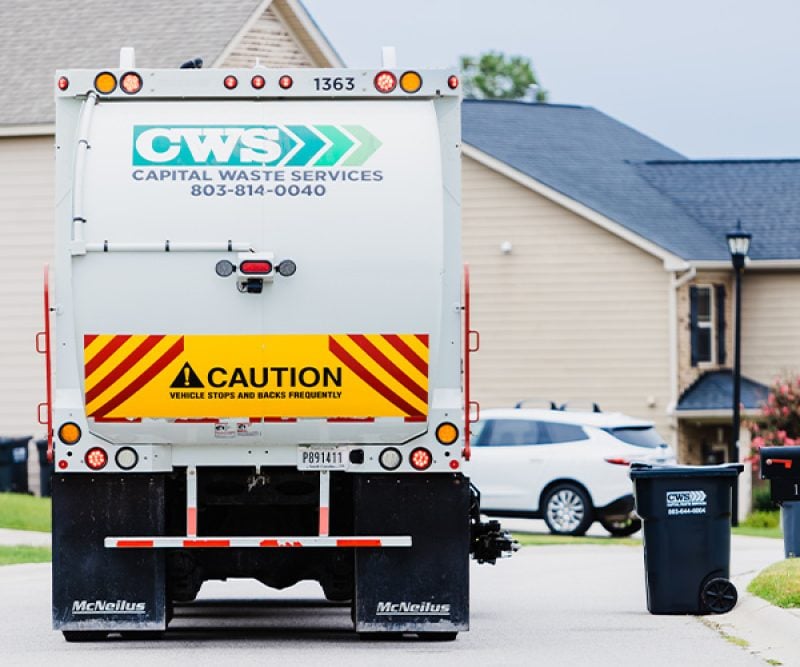 View of the back of a collection truck on a residential street