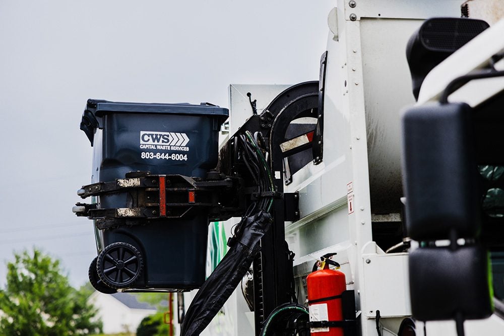 Close up view of a collection truck emptying can into truck